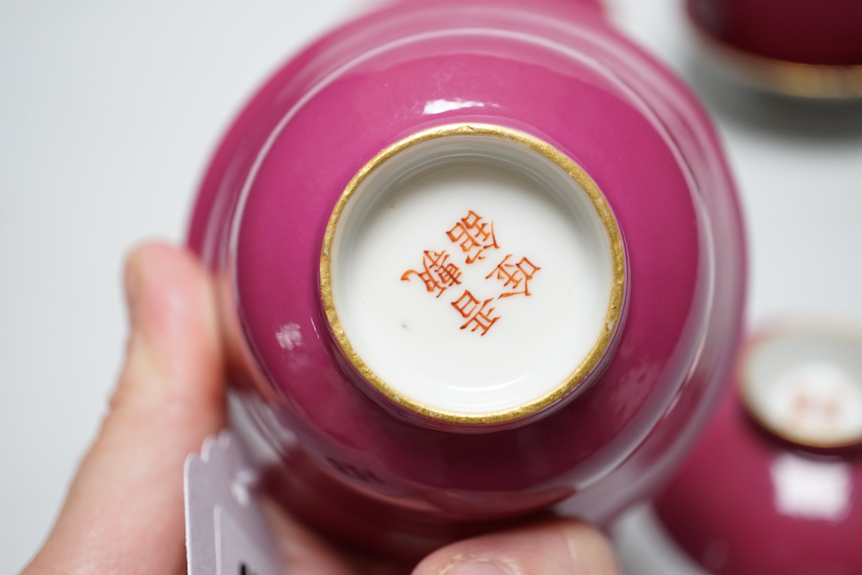 A pair of Chinese ruby ground tea bowls, covers and stands